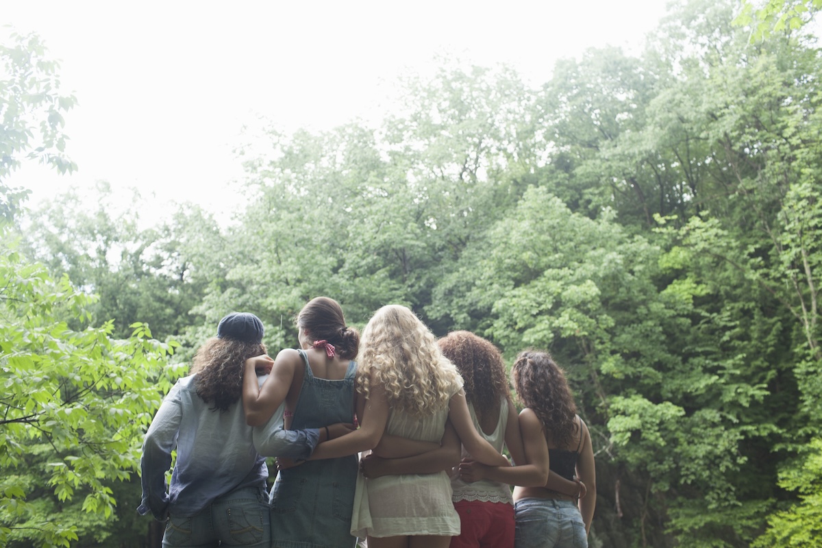 Friends embracing in unity amidst nature